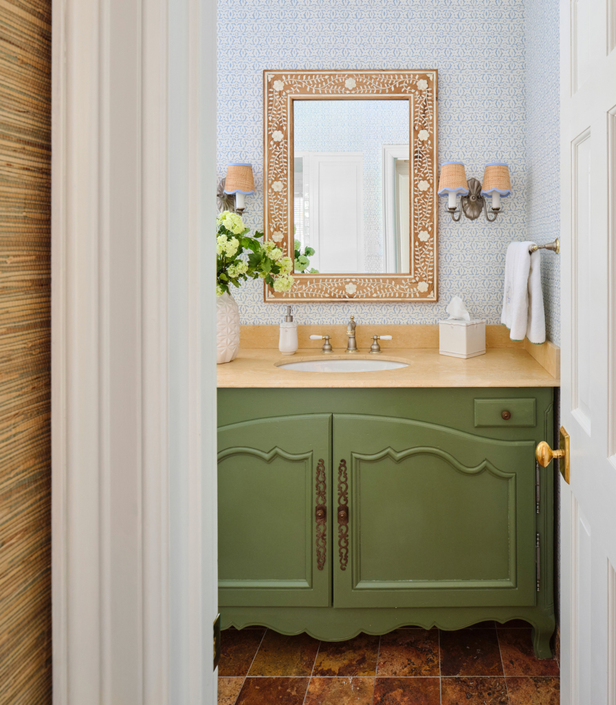 Pale blue wallpaper and a vanity painted in Benjamin Moore "Buckingham Gardens" are a refreshing surprise in this guest bath.