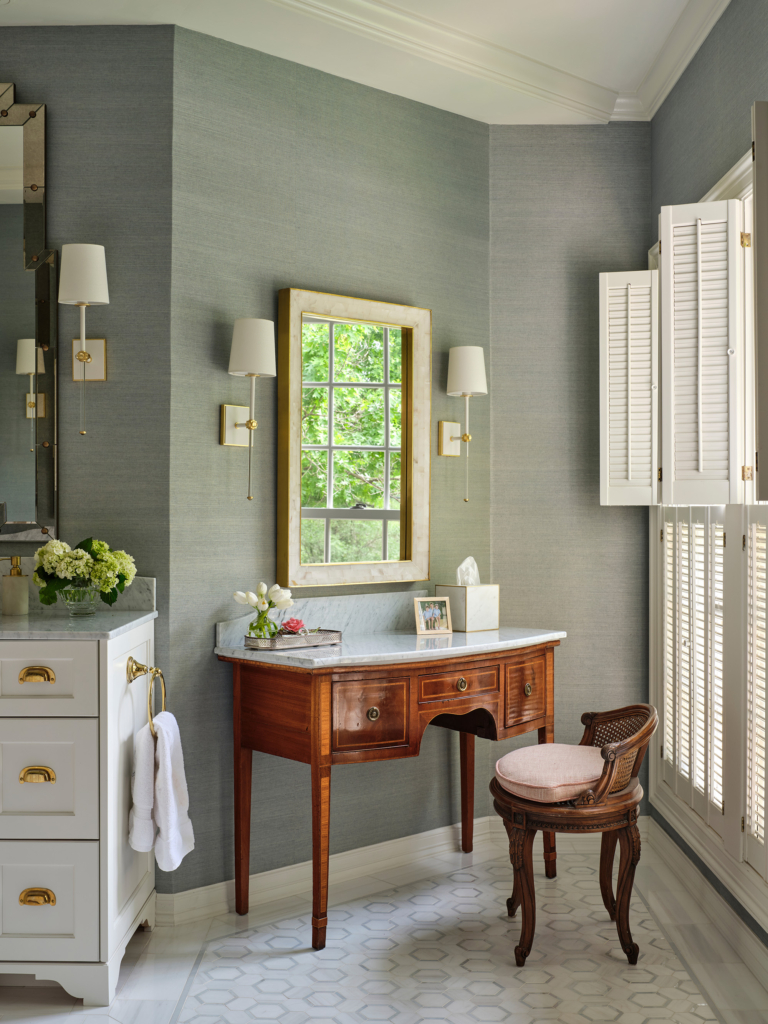 A delicate vanity piece claims a corner in this elegant primary bath.