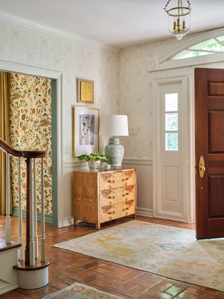 The foyer's Galbraith and Paul "Lotus" wallpaper adds a serene and welcoming touch.