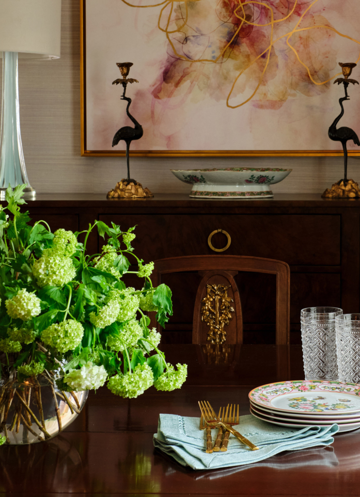 Pink artwork plays off the wallcovering in the dining room.