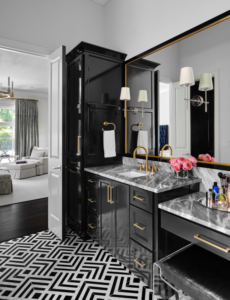 A luxurious Alamo Heights master bath with high-gloss cabinets in Sherwin Williams "Tricorn Black". The black-and-white tile and brass accents are perfect.
