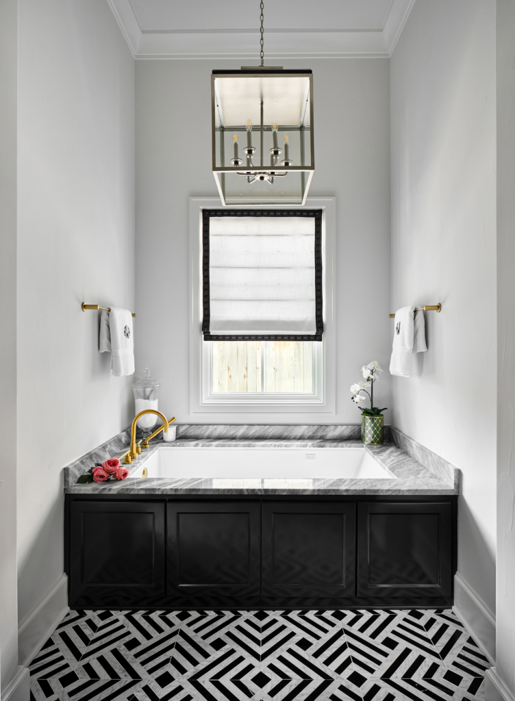 Refined relaxation in the master bath. This Alamo Heights tub area is elevated by high-gloss cabinets painted in Sherwin Williams "Tricorn Black", adding depth and drama to a serene, spa-like space.
