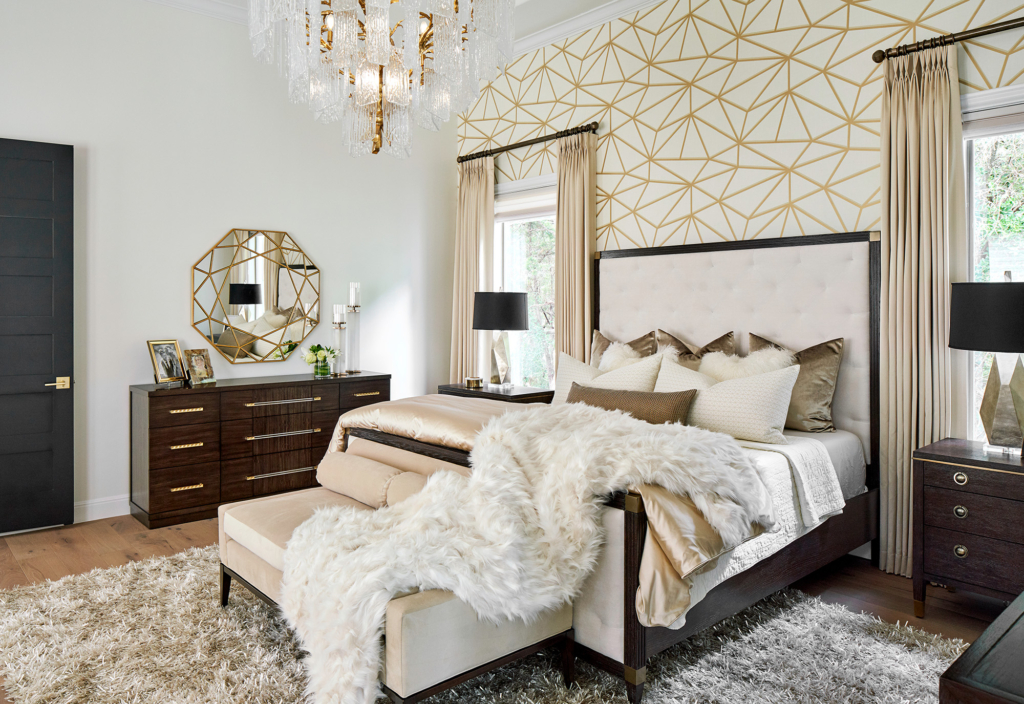 Luxurious primary bedroom with white and gold wallpaper, and a touch of black for contrast.
