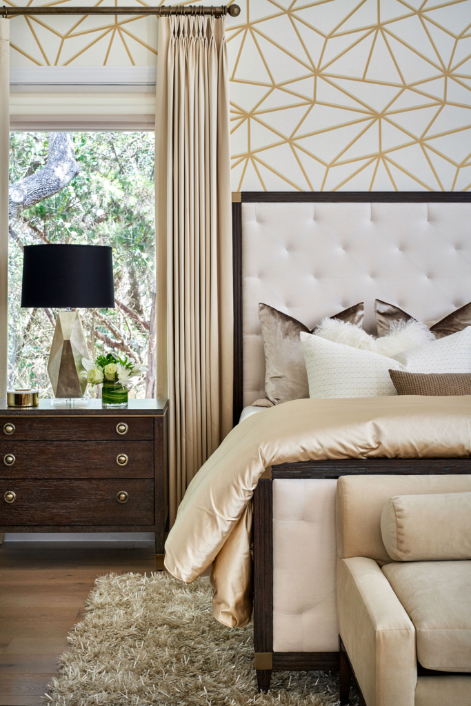 Primary bedroom featuring white and gold wallpaper on the headboard wall.
