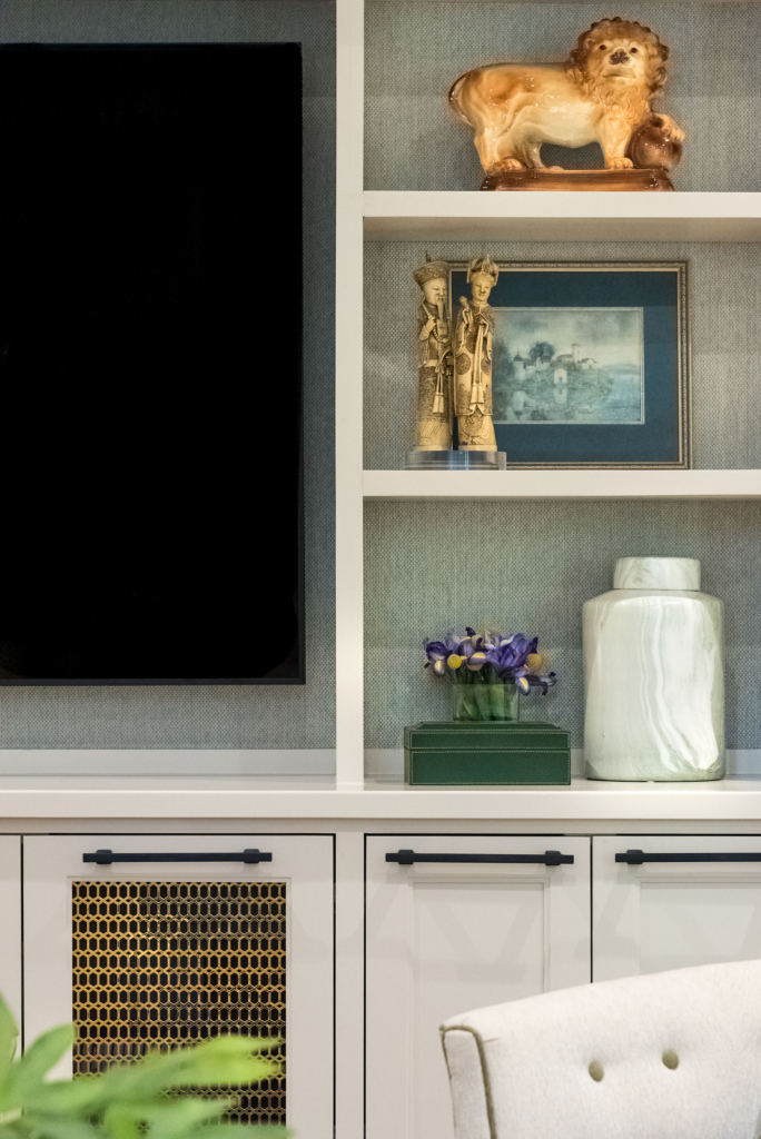 Custom wallpaper installation inside bookcase shelves adds a stylish touch.