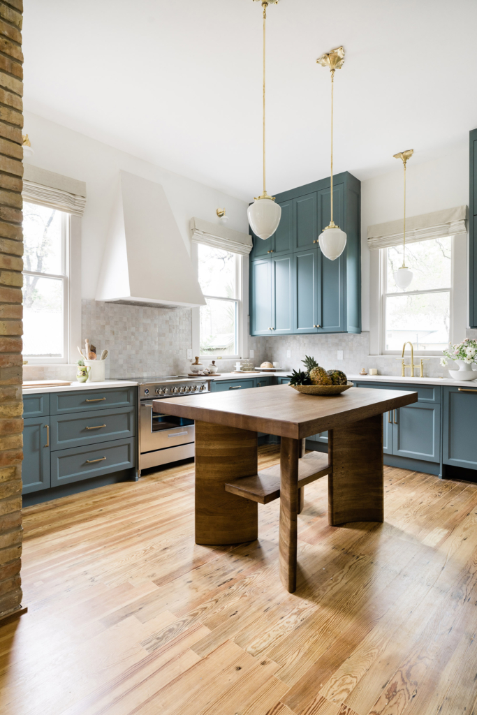 This beautifully renovated Victorian kitchen features striking blue cabinets and crisp walls in Farrow & Ball "All White", plus a hand-made kitchen island.