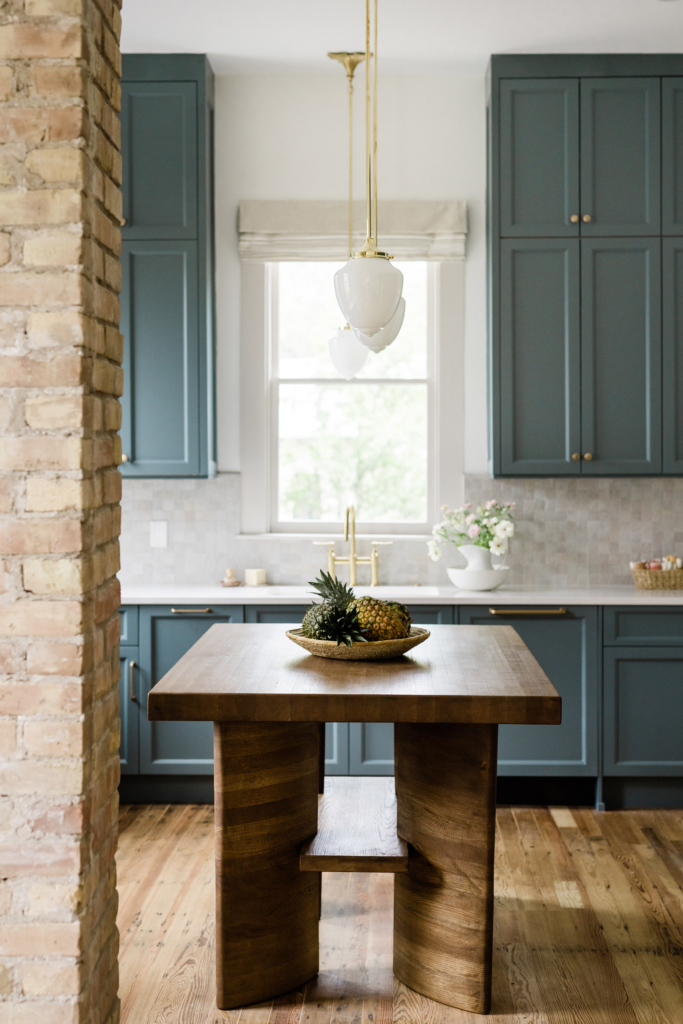 A custom kitchen island pairs nicely with classic blue cabinets. Walls painted in Farrow & Ball "All White".