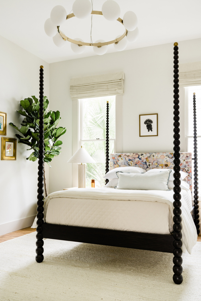The primary bedroom's modern-classic light fixture and Julian Chichester four-poster look great against walls painted in Farrow & Ball All White".