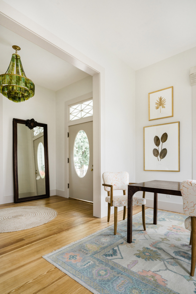 A beautifully restored entry opening into the dining room, with walls painted in Farrow & Ball’s “All White”.