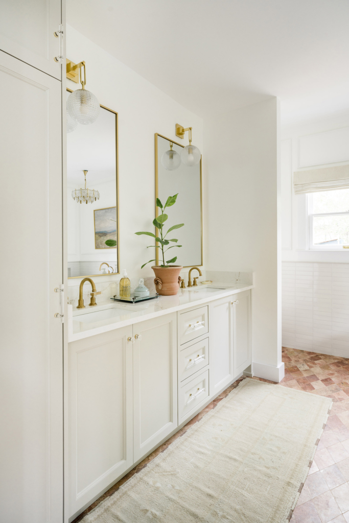 The updated primary bath features walls painted in Farrow & Ball’s “All White", with the vanity in "Skimming Stone".