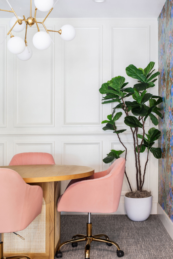 Study and meeting room styled with accent walls in Kristy Stafford "Chelsea Blue" wallpaper, woodwork details, and soft pink chairs.