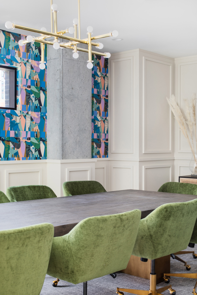 A lively study and meeting room, featuring Kristy Stafford "Basil Bright" wallpaper and bright green chairs.