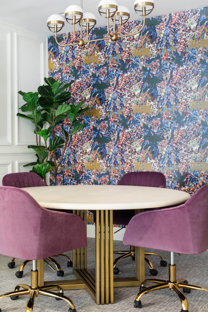 Study room with Kristy Stafford's "Pufflower Gold" wallpaper, vibrant purple chairs and modern luxe details.