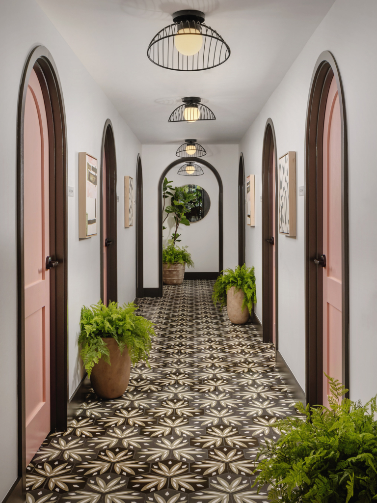 Ordinary hallways become extraordinary with playful pink doors and vibrant floor tile.