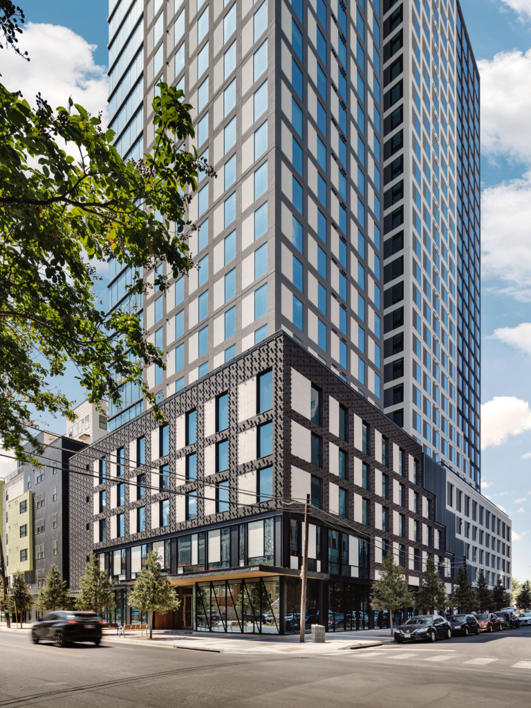 Full street-level view of the Yugo Austin Waterloo tower with its sleek, modern design..