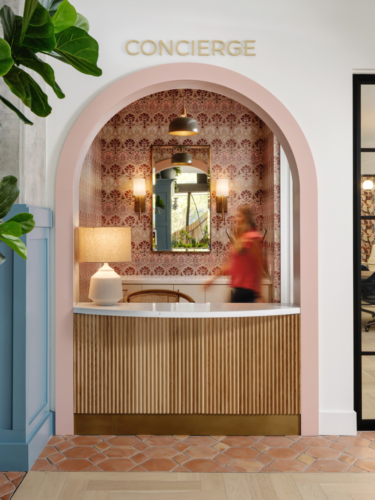 "Blush Daisy Suzani" wallpaper by St. Frank brings warmth and whimsy to the concierge area.