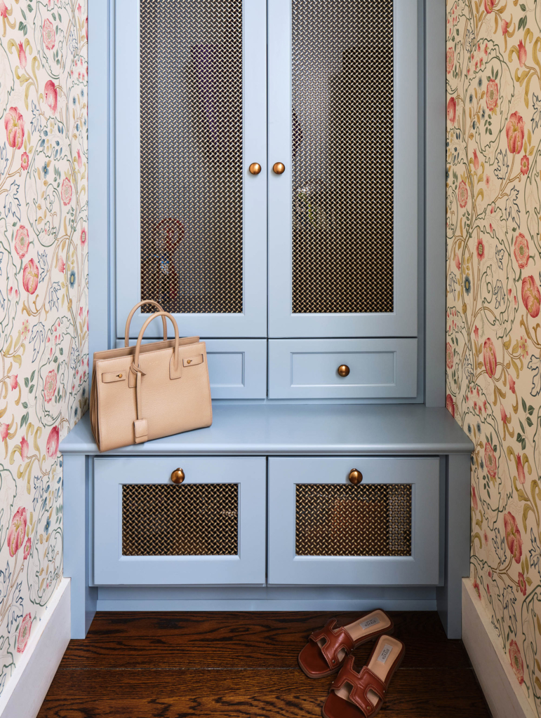 Mudroom with blue cabinets and floral wallpaper.