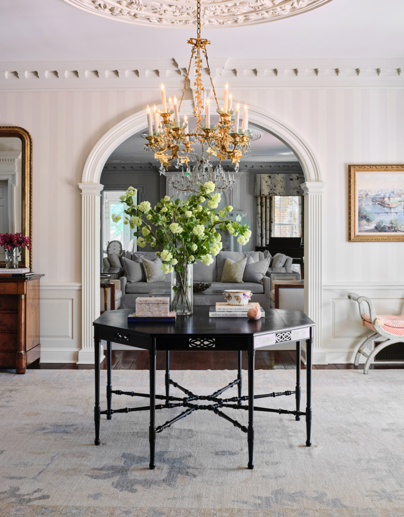 An elegant entry foyer in a traditional home, featuring classic striped wallpaper.