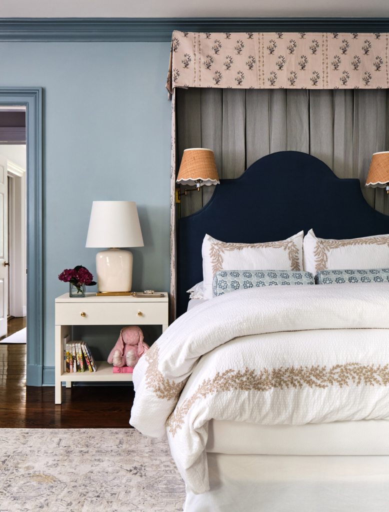 A boys’ kids bedroom with soft blue walls and dark blue trim creates a bold, stylish contrast.