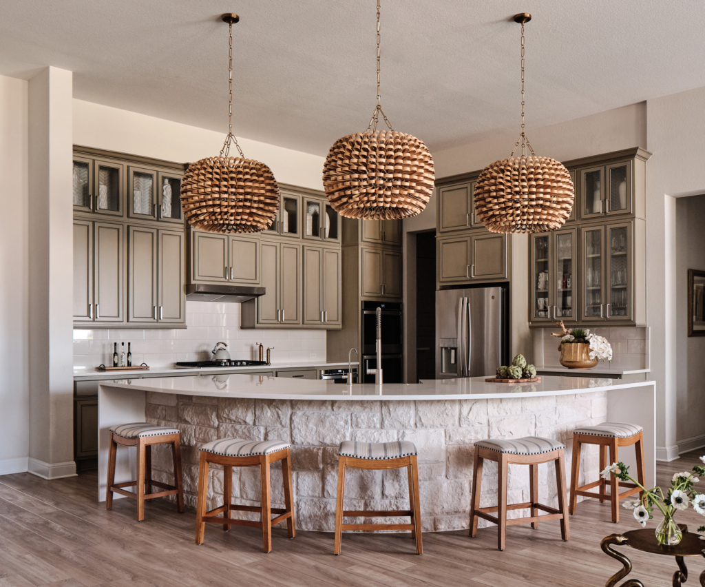 Spacious kitchen featuring sage green cabinets, and wood-textured light fixtures, in this wonderful gathering space.