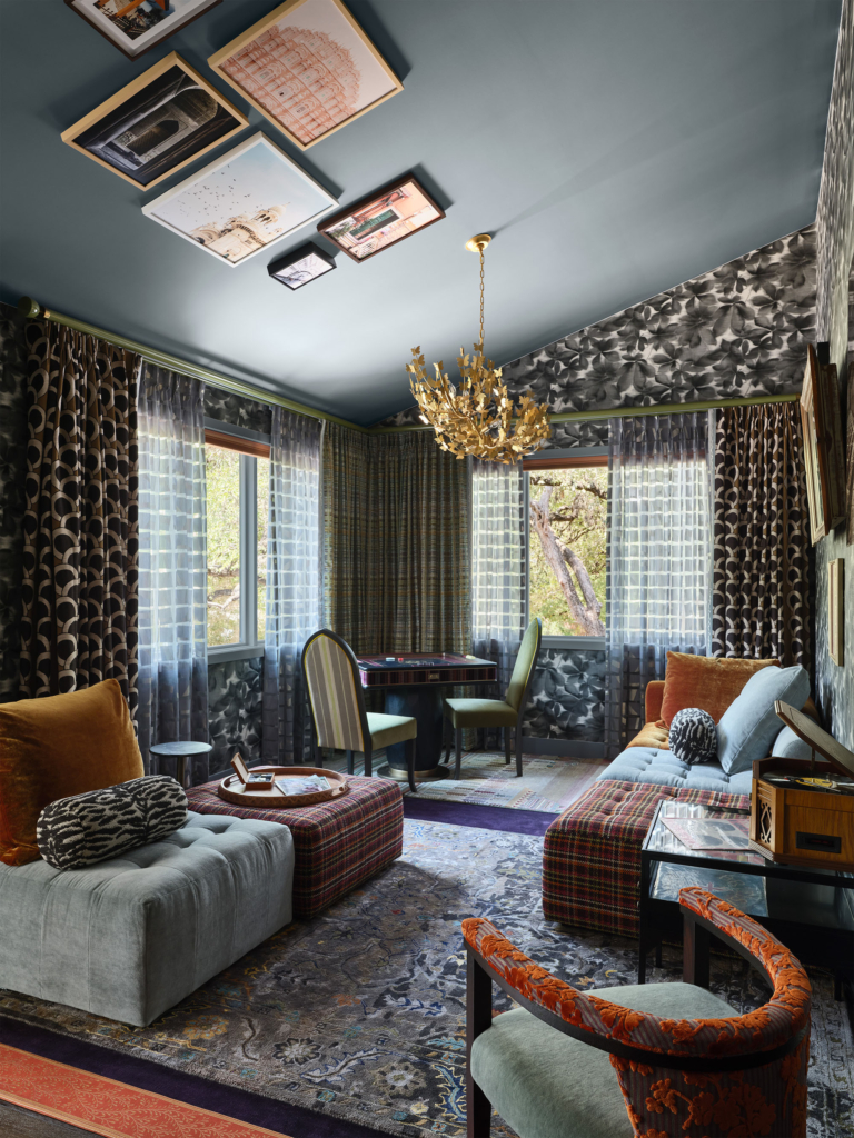 Game room lounge with Harlequin "Grounded" wallpaper on the walls, and art on the ceiling, designed by Rhydima Brar. A playful and artistic space full of pattern and personality.