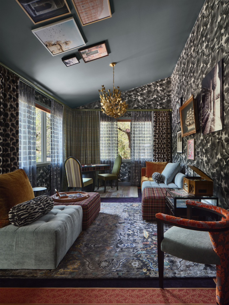 Another view of the game room lounge featuring Harlequin "Grounded" wallpaper on the walls and curated art on the ceiling, designed by Rhydima Brar. A playful and artistic space that balances pattern, color, and creativity.