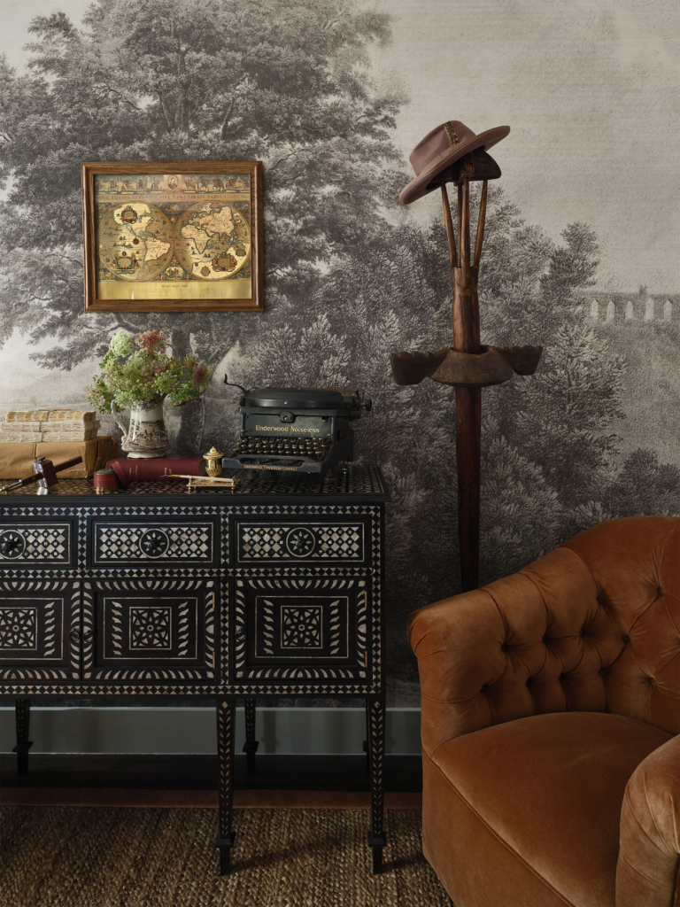 Console in the primary master bedroom featuring Phillip Jeffries "Vista" in Meadow grisaille landscape wallpaper mural, from House Beautiful 2025 in Austin, designed by Kathy Kuo. A detailed look at how artful wallpaper elevates functional furniture.