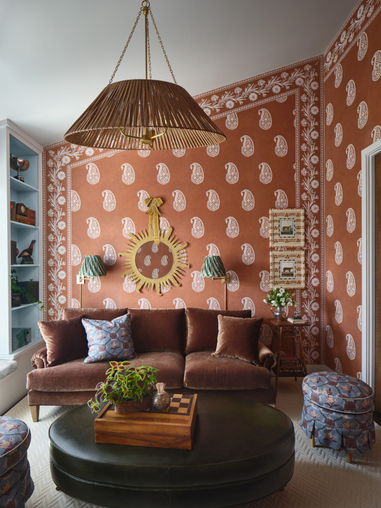 Lounge area featuring Phillip Jeffries custom orange bandana wallpaper with coordinating wallpaper border, designed by Leah O’Connell. A playful and vibrant design with personality and charm.